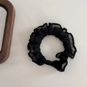 Close-up of black mesh hair scrunchie with lace trim and polished oval bead detail
