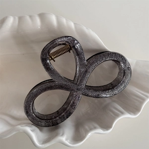Detailed close-up of a graphite grey glitter bow hair claw clip with a gold metal spring