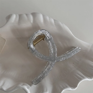 Macro shot of transparent silver glitter hair claw clip with golden metal spring