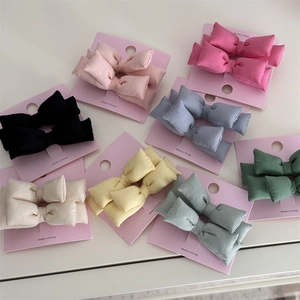 Vue détaillée d'un ensemble de barrettes à nœuds en tissu coloré sur cartes roses