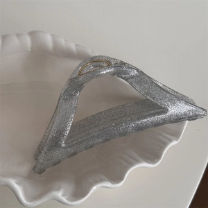 Close-up of a silver glitter hair claw clip with a stylish triangular cutout design