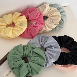 Gros plan de chouchous colorés en coton avec breloques cœur et pierres précieuses