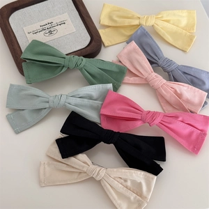 Mise à plat de barrettes à nœuds colorés en tissu jaune, bleu, rose et vert