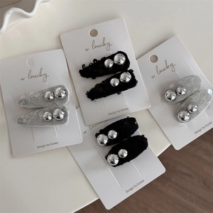 Elegant bow hair clips with silver beads and sequins on a white display card