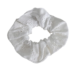 Elegant white scrunchie with delicate floral hollow embroidery and rustic fabric style