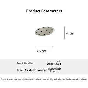 Detailed view of a light gray hair clip with black dots and dimensions 4.5 x 2 cm