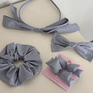 Détail d'un ensemble d'accessoires cheveux en tissu gris fumé avec bandeau et chouchou