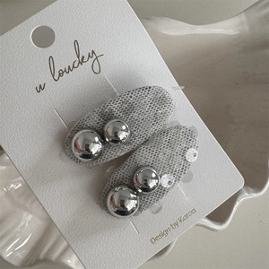 Close-up of grey mesh bow hair clips with silver metallic beads on display card