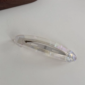 Détail de la barrette ovale longue en acétate avec finitions irisées lilas et vert