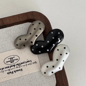 Polka dot heart and peanut shaped hair clips in silver, black, and cream colors