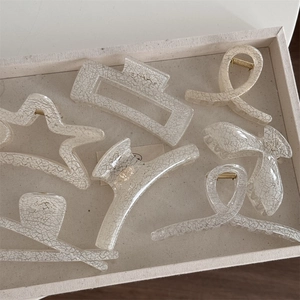 Detail showing the cream-colored crackle texture finish on various hair claw clip designs
