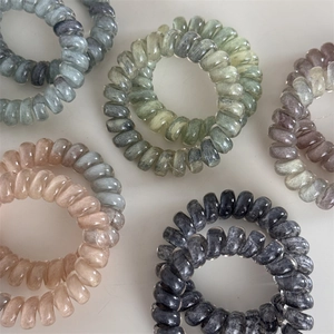Cinq élastiques spirales effet marbre dans des tons gris, vert, violet et rose poudré