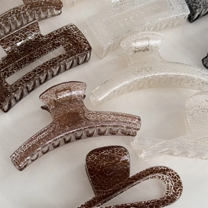 Detail of elegant hair claw clips with unique ice-crackle texture and glossy resin finish