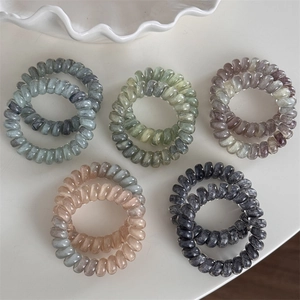 Détail du lot de 10 élastiques spirales avec texture marbrée et finition nacrée
