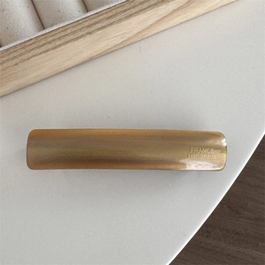 Close-up of amber acetate hair clip featuring gold FRANCE Handmade lettering details