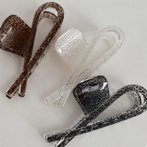 Detail of square hair claws in three colors with artistic ice-cracked resin texture