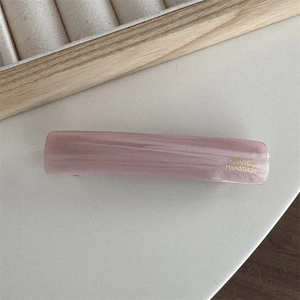 Detail of a pink marbled acetate hair clip featuring gold FRANCE Handmade lettering
