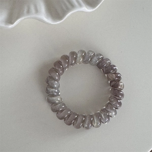 Détail macro d'un élastique spirale dégradé avec finition résine nacrée haute élasticité