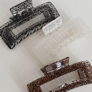 Close-up of three vintage square hair claws with ice-crack texture in neutral colors
