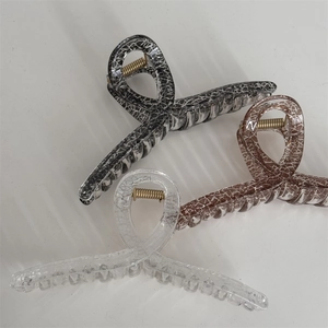Close-up of three large criss-cross hair claws with white marble crackle patterns