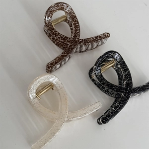 Close-up of three vintage square hair claws in brown, black, and beige with crackle patterns