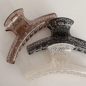 Detailed view of three cracked-pattern hair claws in coffee, black, and cream white colors