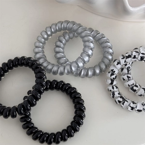 Detail of five-piece spiral phone cord hair ties with milk cow pattern and pearl finish