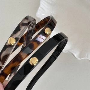 Close-up of leopard and tortoiseshell headbands with golden metal buckle accents