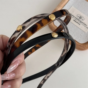 Detail of leopard print and black headbands with gold metallic studs and anti-slip teeth