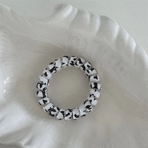 Detail of spiral hair tie with cow print pattern on decorative white shell tray