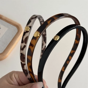 Detail showing inner non-slip teeth and golden metal studs on leopard print headbands