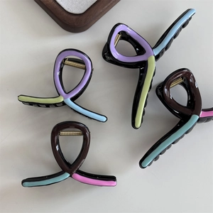 Detail view of colorful wave hair claw clips in purple, green, and blue finishes