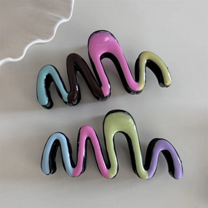 Detail of colorful wavy hair claw clips with glossy finish and multi-color patchwork design