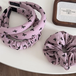 Détail d'un ensemble de 4 accessoires cheveux violets avec motifs nœuds noirs et étiquettes