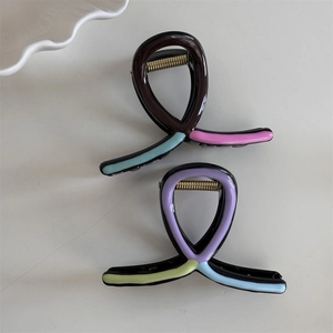 Top view of wave-shaped hair clips in colorful drip oil finish with gold metal spring
