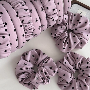 Détail du bandeau lavande et chouchou avec motifs à pois noirs et nœuds élégants