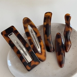 Detailed set of five tortoiseshell acetate hair clips with classic amber textures and metal backs