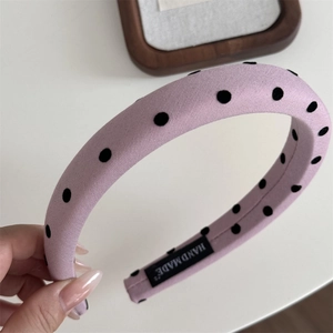 Gros plan du serre-tête lavande à pois montrant l'étiquette Hand Made et le tissu