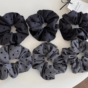 Set of six black and grey fabric scrunchies with polka dot and heart embroidery patterns