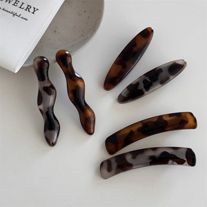 Detailed close-up of a 6-piece acetate hair clip set with amber and leopard print patterns