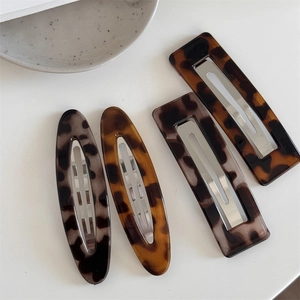Set of four tortoiseshell acetate hair clips in oval and rectangular shapes with metal grips