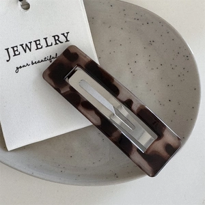 Close-up of tortoise shell pattern acetate hair clip with silver metal snap