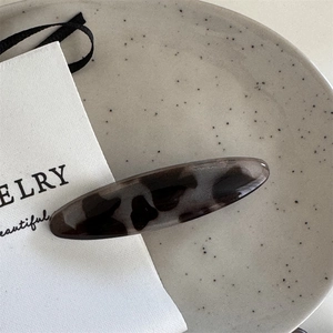 Detail shot of a large oval leopard print hair clip with smooth acetate texture finish
