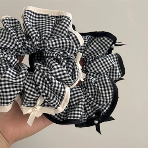 Détail d'un chouchou à carreaux avec mini-nœuds et perles blanches pour la coiffure