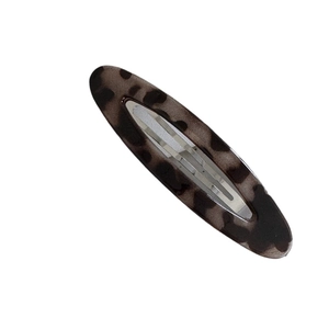 Elegant leopard print oval hair clip with silver metal back on a plain white background