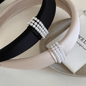 Elegant sponge padded headband with white faux pearls in black and beige satin finish