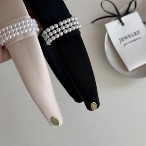 Detail showing elegant black and beige satin headbands with triple rows of white pearls