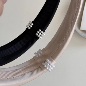 Close-up of elegant black and champagne headbands with clustered pearl detailing