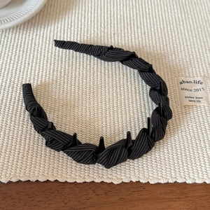 Vue détaillée d'un serre-tête tissé à rayures noires avec peigne intérieur antidérapant