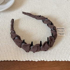 Vue détaillée du serre-tête en tissu à rayures marron avec dents antidérapantes